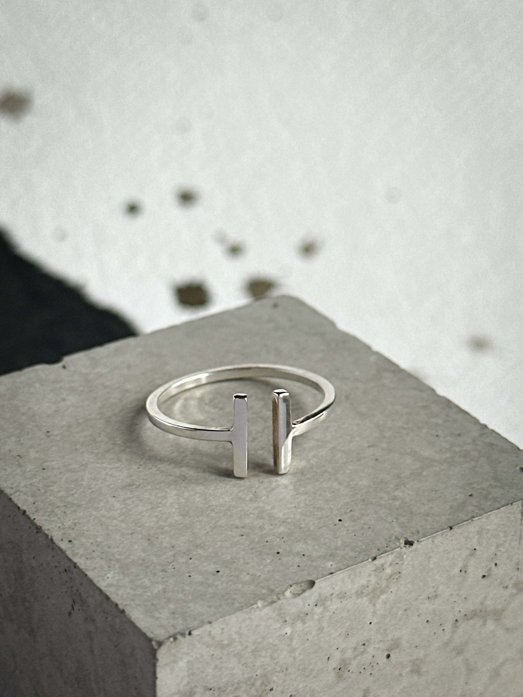 Silver ring with vertical bars on a concrete surface