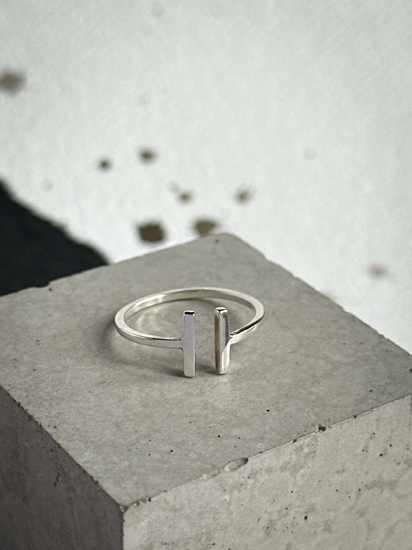 Silver ring with vertical bars on a concrete surface