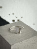 Silver ring with vertical bars on a concrete surface