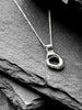 A silver necklace with a textured, organic-shaped molten circle pendant