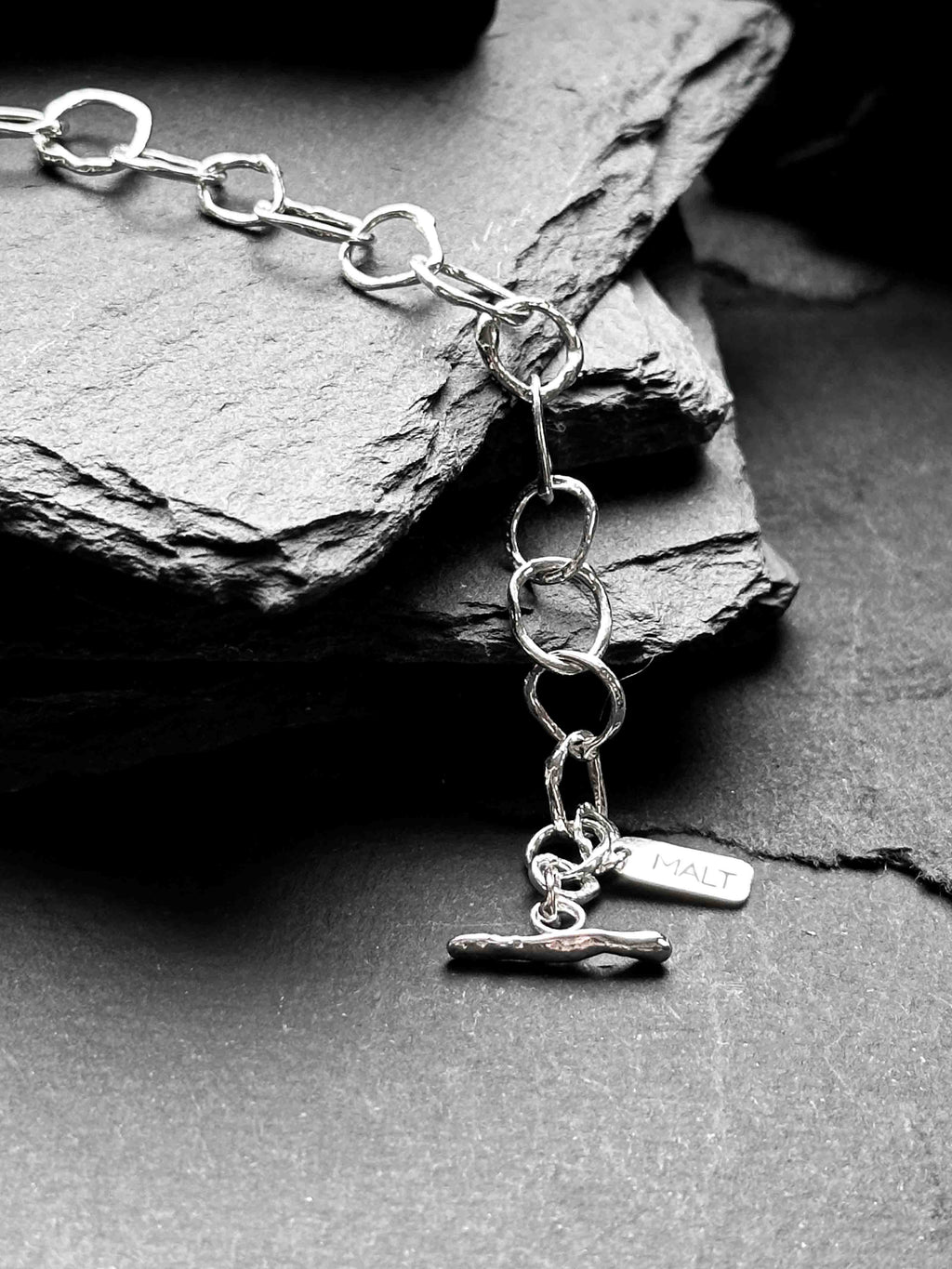 Molten asymmetrical skinny link sterling silver bracelet with single chunky contrasting oval link and T-bar toggle clasp