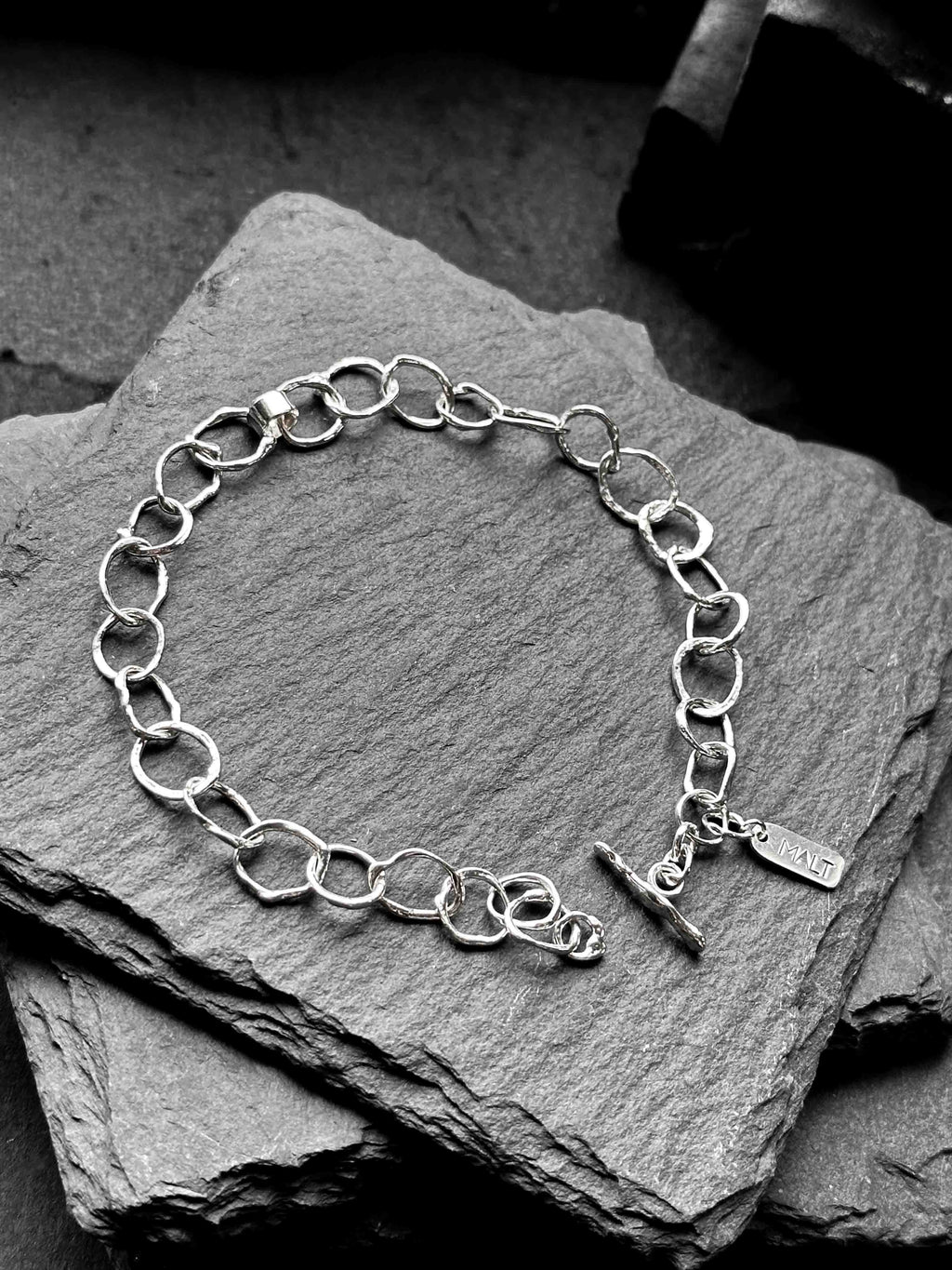 Molten asymmetrical skinny link sterling silver bracelet with single chunky contrasting oval link and T-bar toggle clasp