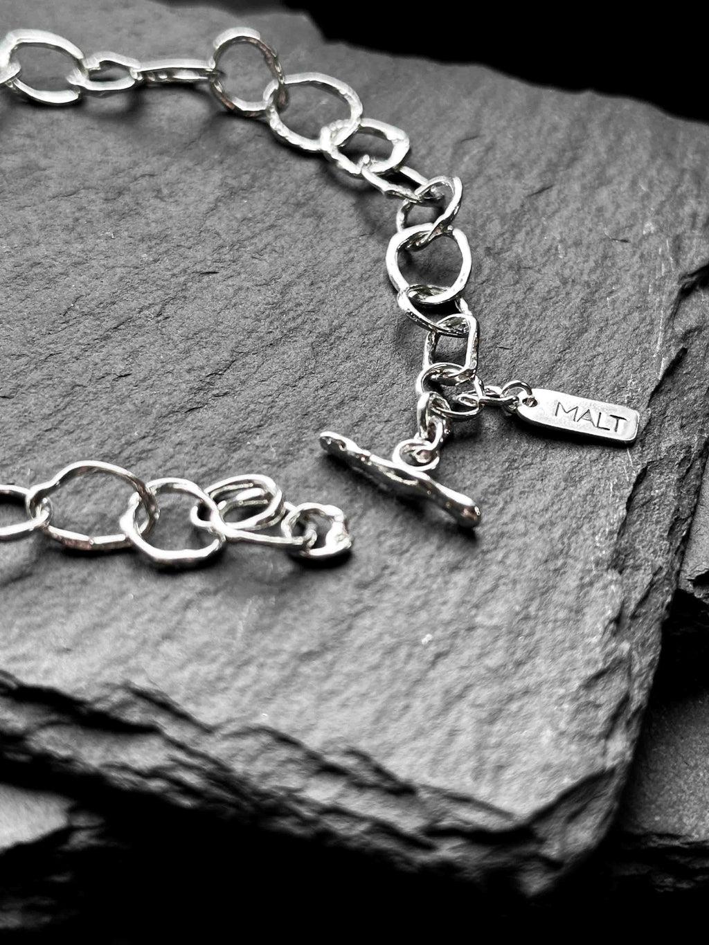 Molten asymmetrical skinny link sterling silver bracelet with single chunky contrasting oval link and T-bar toggle clasp
