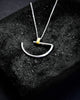 A large minimalist semi-circle pendant in silver with contrasting gold-coloured bar bail on a chunky chain.