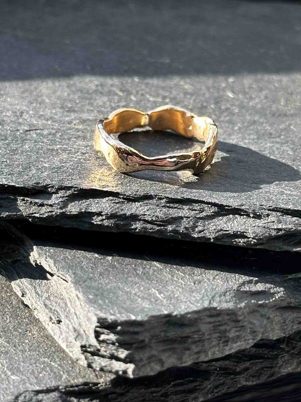 A textured, organic ring, gold wedding band in an alternative style