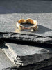 A textured, organic ring, gold wedding band in an alternative style