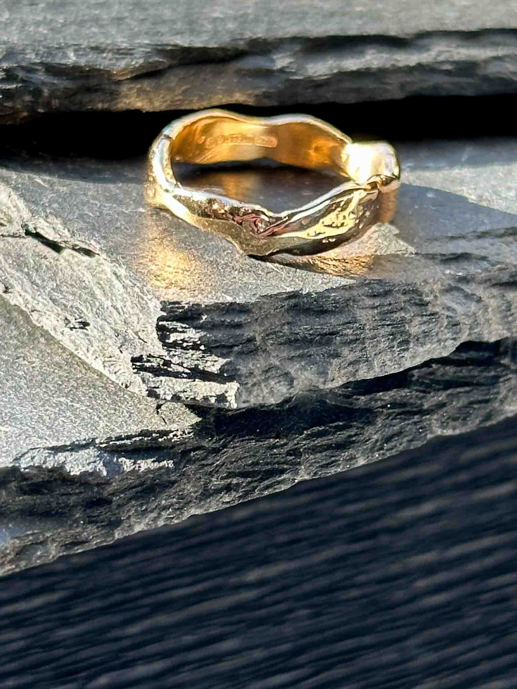 A textured, organic ring, gold wedding band in an alternative style