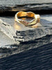A textured, organic ring, gold wedding band in an alternative style