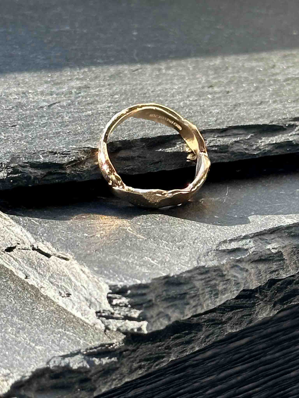 A textured, organic ring, gold wedding band in an alternative style