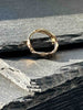 A textured, organic ring, gold wedding band in an alternative style