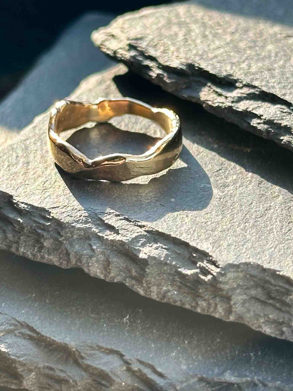 A textured, organic ring, gold wedding band in an alternative style