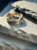 A textured, organic ring, gold wedding band in an alternative style