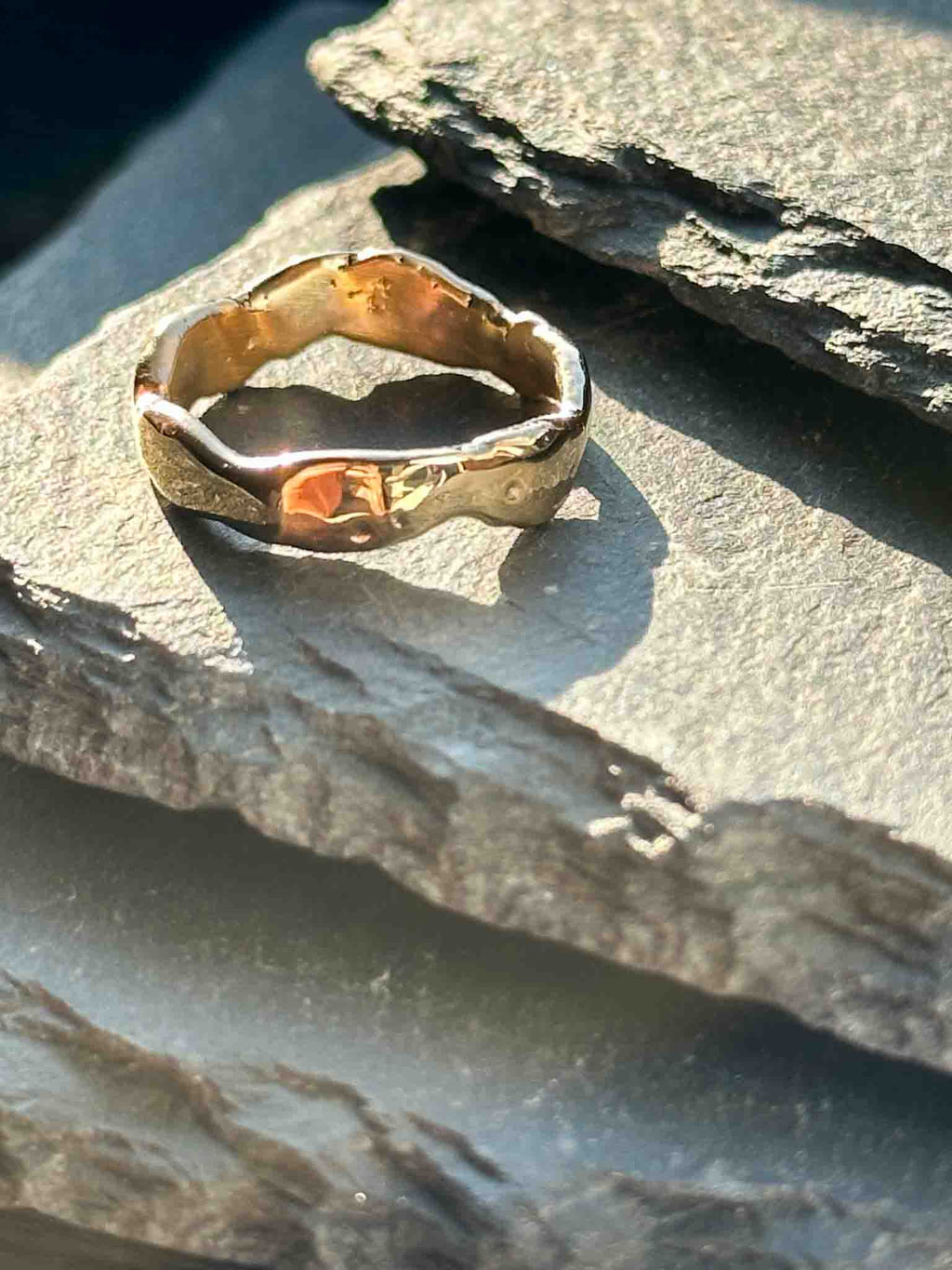 A textured, organic ring, gold wedding band in an alternative style