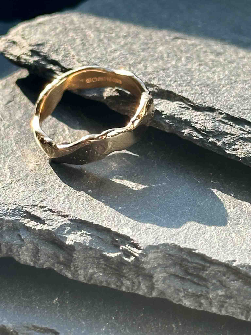 A textured, organic ring, gold wedding band in an alternative style